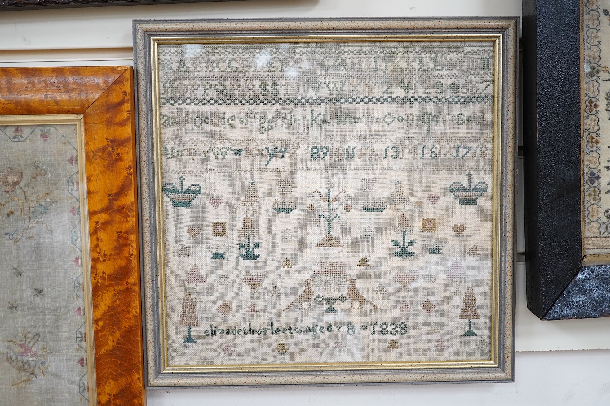 An early 19th century sampler dated 07, by Sarah Baker, ‘Henry IV’s Soliloquy of Sleep’, together with a later smaller alphabet and spot motif sampler by Elizabeth Fleet aged 8, dated 1838, both framed